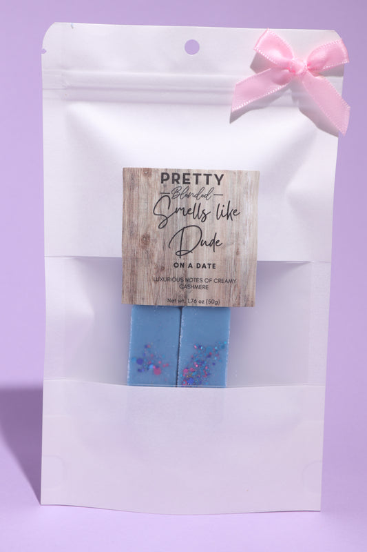 Soy wax melts in a white packaging with a pink bow on a purple background